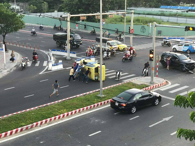 Taxi lật nghiêng, hàng chục người đẩy xe cứu tài xế